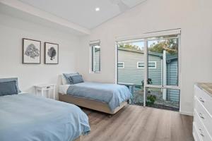 邓斯伯勒Willy Wagtail @ Cape Villas的一间卧室设有两张床和大窗户