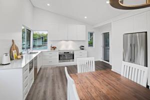 邓斯伯勒Willy Wagtail @ Cape Villas的厨房铺有木地板,配有白色橱柜。