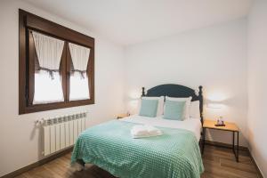 阿尔苏阿Apartamentos Luis的一间卧室配有一张带绿毯的床和窗户。