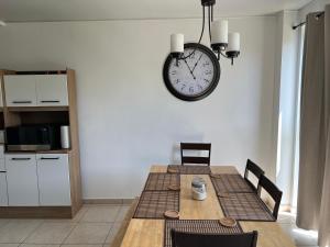 松索纳特Comfortable and roomy, in Sonsonate的一间设有桌子和墙上时钟的餐厅