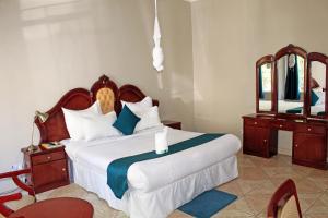 卢萨卡Fatmols Hotels的一间卧室配有一张大床和镜子