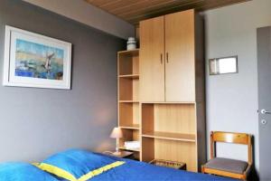 奥斯坦德De Strandwandeling 0203 Appartement met frontaal zeezicht的一间卧室设有蓝色的床和书架