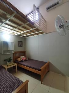 关丹BR Guesthouse Kuantan的小房间设有一张床和一个风扇