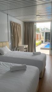 科亚Meraga Cinta Kijal的一间卧室设有两张床,享有游泳池的景色