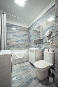 雅西LUXURY Cozy Apartments and Studios Palas Mall Iasi的浴室配有卫生间、盥洗盆和浴缸。