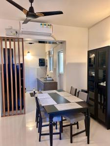 达波林Good Stay 2 BHK Flat 301的一间带桌子和吊扇的用餐室