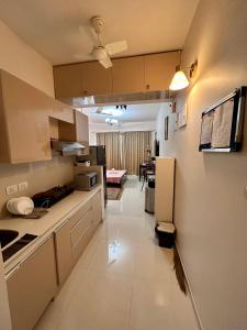 达波林Good Stay Premium Studio Apartment 206的一间带白色橱柜的厨房和一间客厅