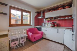 弗塞廷Wellness Chalupa Benešky的一间厨房,在房间内配有粉红色的椅子