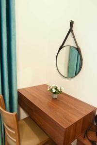 顺化AnAn Homestay Huế的一张带镜子和花瓶的木桌
