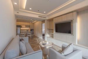 曼谷茉莉花豪华公寓的客厅配有白色沙发和电视