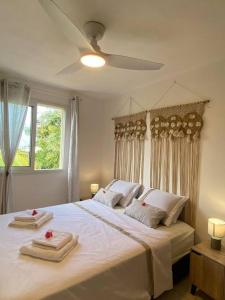 圣皮埃尔Villa Albizia 974 avec piscine et spa的卧室配有带毛巾的大型白色床