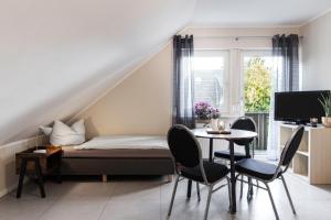 诺德施泰特Pension Haus am Kohfurth的卧室配有一张床和一张桌子及椅子