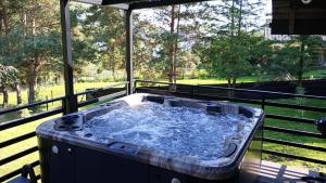 RopaCzarna Chata II Luxury Resort的树景甲板上的热水浴池