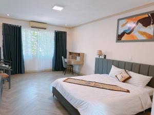 Bình SơnKhách Sạn Hoàng Mai Dung Quất的一间卧室配有一张床和一张书桌