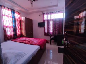 钱德加尔Hotel Yolo的一间卧室配有一张带红色床单和窗户的床。