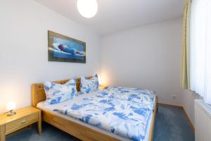 米特尔巴赫Pension Klug Adults only - DorfResort Mitterbach的一间卧室配有一张带蓝色床单和枕头的床。