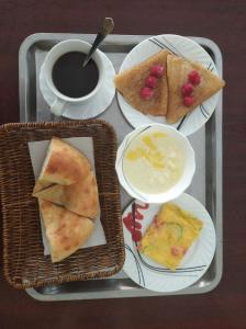 撒马尔罕Hotel Marvarid的盘子,盘子上放着三盘食物和一杯咖啡