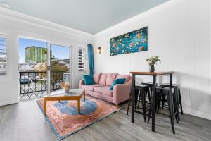 凯恩斯沃克吕兹别墅公寓的客厅配有粉红色的沙发和桌子