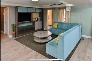 坦帕Red Roof Inn PLUS & Suites Tampa的客厅配有蓝色的沙发和桌子