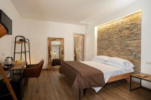 阿纳卡普里alle Stelle b&b的一间卧室设有一张床和砖墙