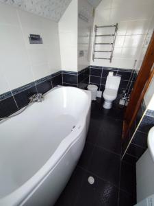 亚列姆切Садиба АнноМарі - відпочинок в Карпатах котедж Яремче的浴室配有白色浴缸和卫生间。