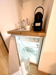 菲拉赫SmartRooms24的一台带咖啡壶的小冰箱,其门是打开的
