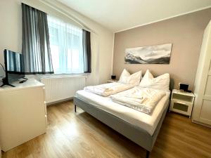 菲拉赫SmartRooms24的一间卧室配有一张带白色床单的床和电视。