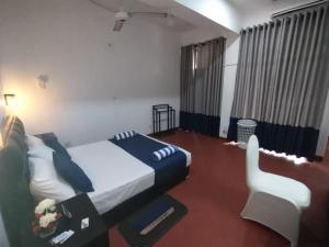 WatumullaHotel Mount Lanka的一间卧室配有一张床和一把椅子