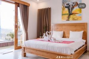 库布盼洛坎Sari Sky Bali的卧室配有一张挂着大象照片的床。
