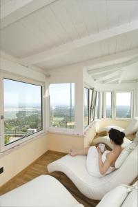 塞尔瓦迪法萨诺Al Mirador Resort的女人躺在窗户房间里的床上
