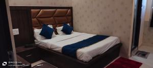 勒克瑙HOTEL PLUTUS的一间卧室配有一张带蓝色枕头的大床