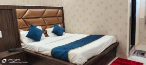勒克瑙HOTEL PLUTUS的一间卧室配有一张带蓝色枕头的大床