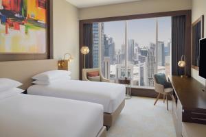 多哈Delta Hotels by Marriott City Center Doha的酒店客房设有两张床和大窗户。