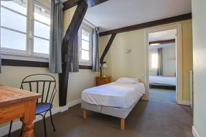 凯恩弗朗索瓦德奥酒店的一间小卧室,配有一张床和一张桌子及椅子