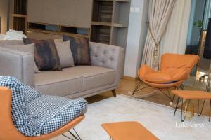 海岸角Executive Suite Apartment in Cape Coast - Lakeview by Agnes的客厅配有沙发和椅子