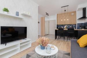 格但斯克Modern Apartment with Balcony by Renters的一间带大电视和厨房的客厅