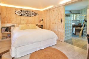 Saint BarthelemyCase Canne a sucre的一间设有白色床的卧室,位于带木墙的房间
