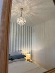 马里纳·迪·比萨Il Faro beach house的一间卧室配有一张床和一个吊灯