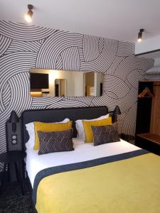 巴黎莫迪利亚尼别墅蓝色假日酒店的一间卧室配有一张大床,提供黄色和黑色的枕头