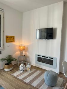 马里纳·迪·比萨Il Faro beach house的一间客厅,在白色的墙上配有电视