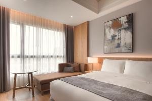 台南禧榕轩大饭店的酒店的客房 - 带一张床、椅子和窗户