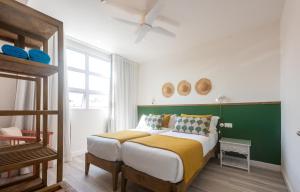 格兰贝伊Dodo Square的一间卧室设有一张大床和绿色的墙壁