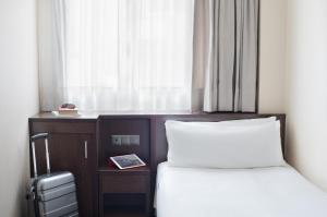 巴塞罗那Hotel Lugano Barcelona的酒店客房设有两张床和窗户。