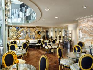 维也纳维也纳公园凯悦酒店的餐厅设有桌椅和大镜子