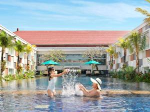 库塔巴厘岛国际机场诺富特酒店的一名在度假村水中玩耍的儿童