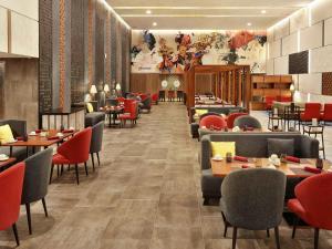 库塔巴厘岛国际机场诺富特酒店的一间带桌椅的用餐室和一间餐厅