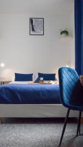 格但斯克Mile Gdansk Airport的一间卧室配有蓝色的床和蓝色椅子