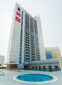 富查伊拉诺富特富查伊拉酒店的一座高大的建筑,前面有一个游泳池