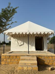 KhuriJaisalmer Safari Base & Camp的白色的帐篷位于田野中