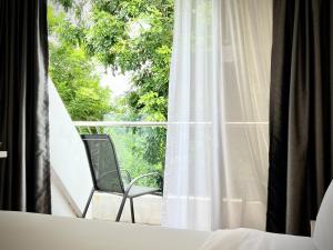 新加坡Rest Bugis Hotel的椅子坐在阳台,可望见窗外